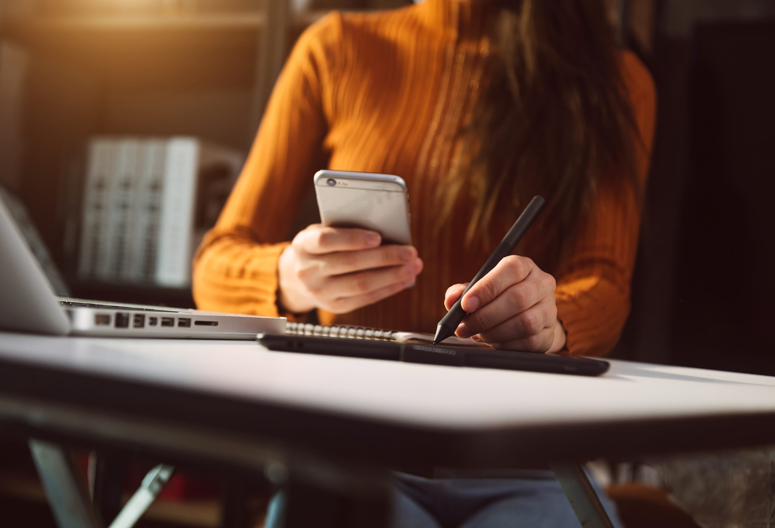 business hand working with new modern computer and writing on the notepad strategy diagram as concept morning light