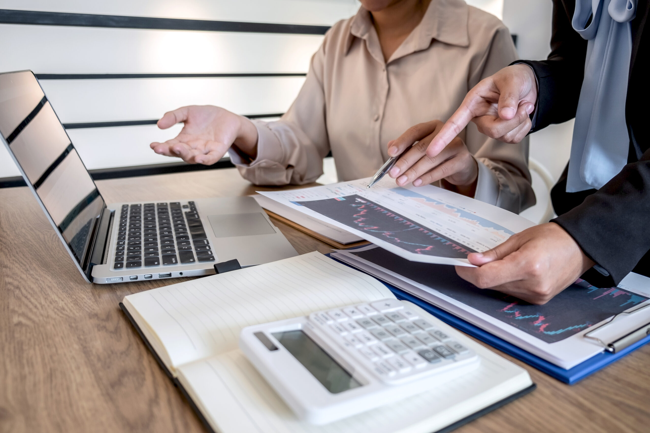 Businesswoman investor on meeting having planning and analyzing of partner cooperation in investment trading marketing project and pointing on the data presented and deal a stock exchange to profit.